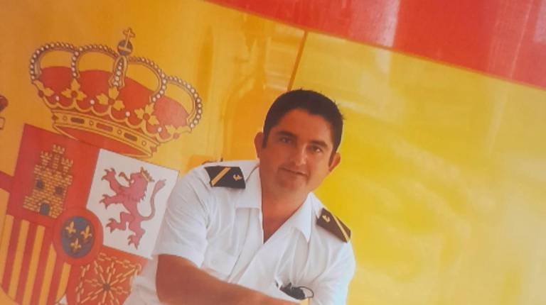 <i>Miguel Ángel López Cerrillo posa delante de la bandera de España.</i>