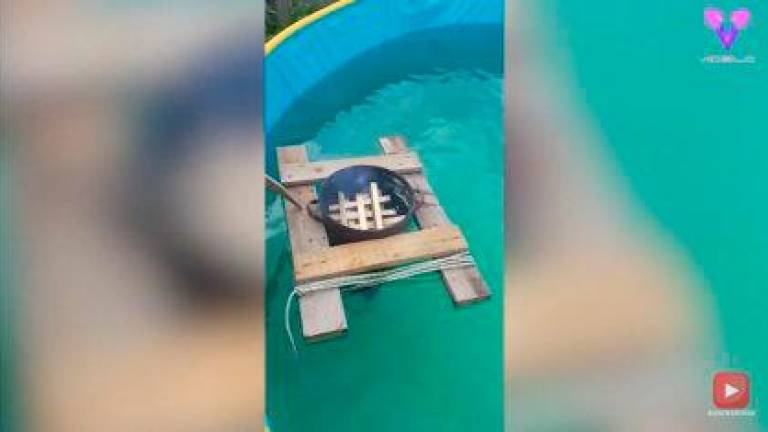 Un hombre calienta su piscina exterior con una hoguera flotante