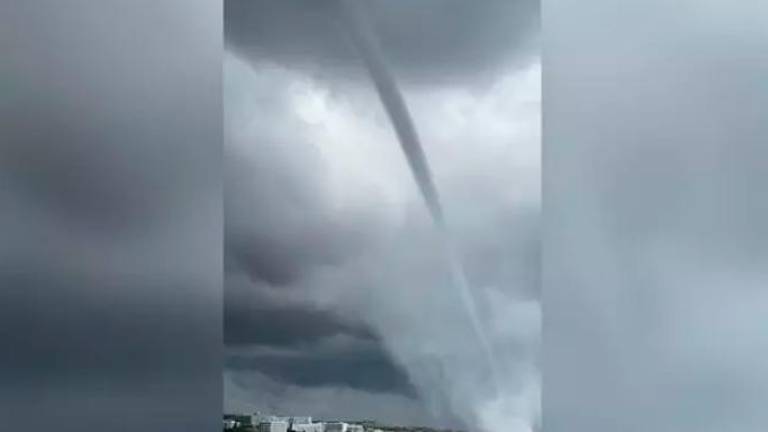 Un turista caza con su cámara este tornado de agua
