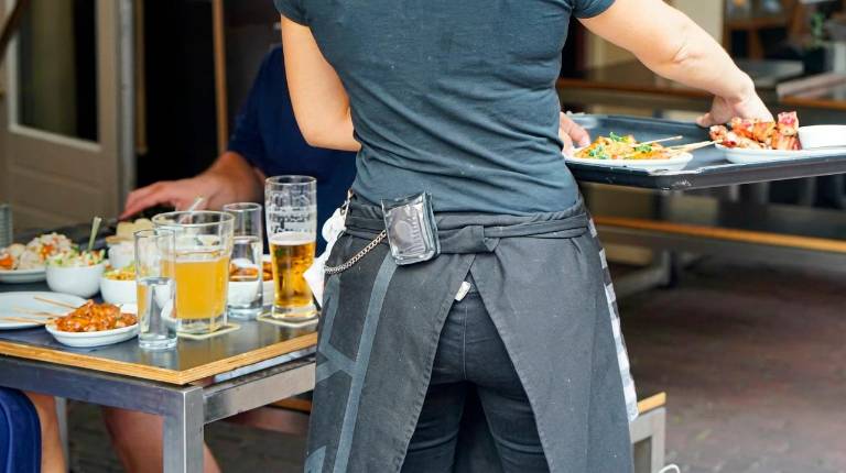 <i>Una camarera atiende a un cliente en un bar. </i>