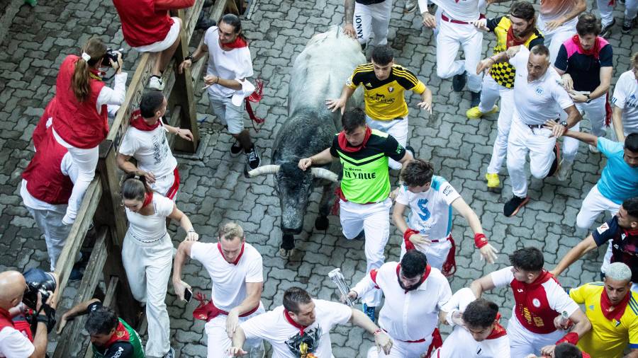 <i>Álvaro Moyano, con la camiseta verde fosforescente, junto a un toro en uno de los encierros de este año. </i>