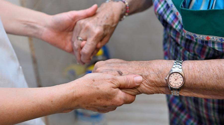 <i>Una auxiliar del servicio de ayuda a domicilio de Atende, acompaña a un usuario.</i>