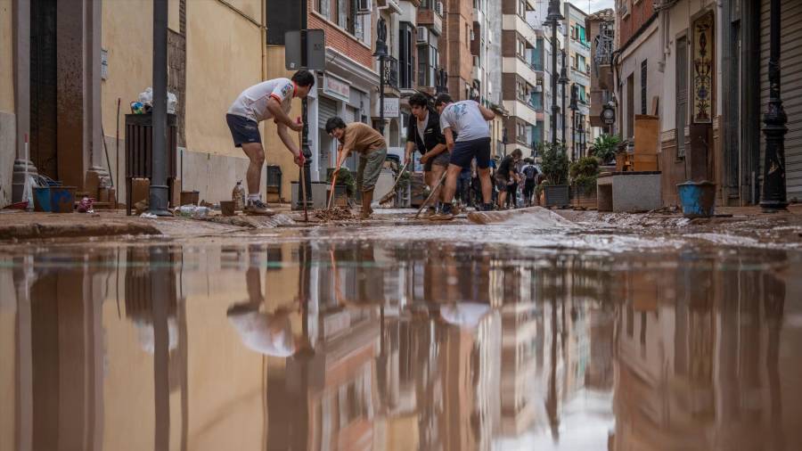 <i>Varias personas colaboran en las labores de limpieza, en Aldaia. / Jorge Gil / Europa Press. </i>