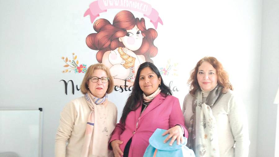 <i>Antonia Algar y Paula Herrera entregan una bolsa con enseres a una madre de la provincia.</i>
