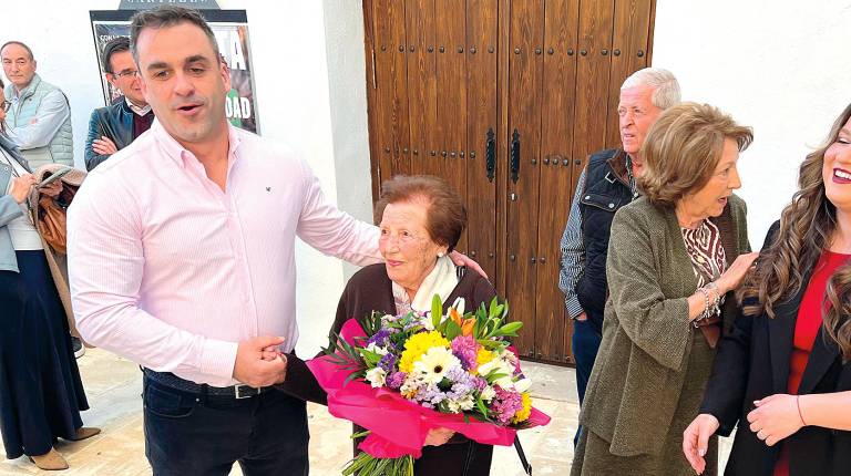 <i>Imagen del alcalde de Begíjar entregando un ramo de flores a María Catalina Soto, junto a vecinos y compañeros de gobierno. / A. Guzguti. / Diario JAÉN.</i>