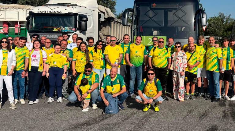 <i>Los aficionados del Jaén Paraíso Interior posan delante de los autobuses en un receso en el viaje.</i>