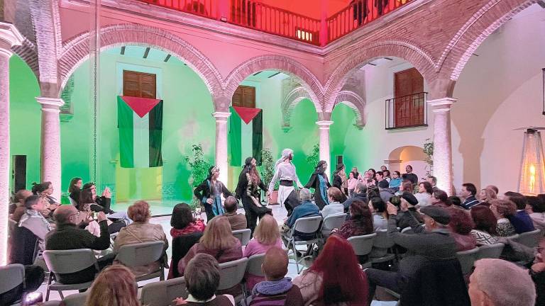 El patio interior de los Baños Árabes, iluminado con los colores palestinos, con un público entregado a los bailarines del Grupo Watani. / Álvaro Guzguti / Diario JAÉN.