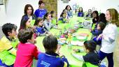 ACEITE. Lola Sagra, Isabel Cabello y Soledad Román junto a los menores inscritos en “Meriendas Saludables”.