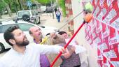 EN LA LUCHA. Francisco Cantero y Manuel Salazar pegan carteles en la zona del Paseo de Linarejos.