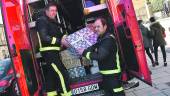 SOLIDARIDAD. Dos miembros de la plantilla de bomberos descargan los regalos recogidos en el parque.