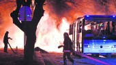 EXPLOSIÓN. Bomberos trabajan para sofocar las llamas ocasionadas por la bomba al paso del autobús militar.