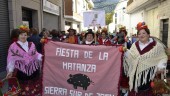 Varias vecinas caracterizadas con atuendos propios de matanza, posan con el cartel de la fiesta durante el desfile por las calles del municipio. Manuela Millán