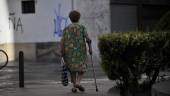 DE PASEO. Una anciana camina por la Plaza de San Ildefonso con la ayuda de una muleta mientras que agarra el bolso con la mano izquierda.