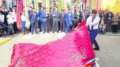 DEVOCIÓN. Un abanderado tremola la bandera frente al popular “Cuadro de la Virgen” durante el pasacalles.