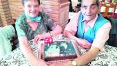 TARTA. Amelia Martínez y Manuel González unen sus manos en forma de corazón junto a la foto de su boda.