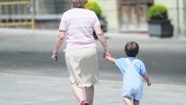 niñera. Una abuela lleva de la mano a su nieto. 