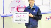 FORTUNA. Pedro Jesús García-Rabadán, gerente de la administración El Madroño, sostiene el cartel que certifica que ha vendido un boleto agraciado con más de 30.000 euros.