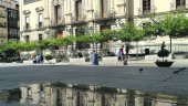 DEUDA. Fachada del Ayuntamiento reflejada en un charco de la plaza.