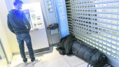 EN UN CAJERO. Un sintecho, envuelto en un saco de dormir, y acostado en la entrada de un banco. 