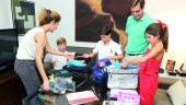 PREPARATIVOS. Marina, Álvaro y Pedro, con su padre Pedro y Jimena ordenan en el salón el material escolar que necesitarán en breve. 