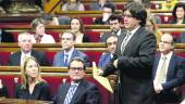 MOMENTO. El “president” de la Generalitat y alcalde de Girona, Carles Puigdemont, abraza al anterior presidente de la Generalitat, Artur Mas, en el Parlamento de Cataluña.