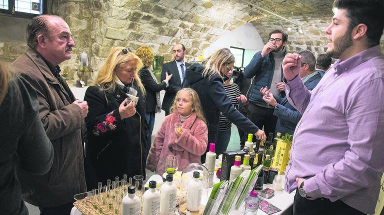 PROMOCIÓN. <i> Visitantes en la Jornada de Puertas Abiertas degustan algunos de los aceites presentados. </i>