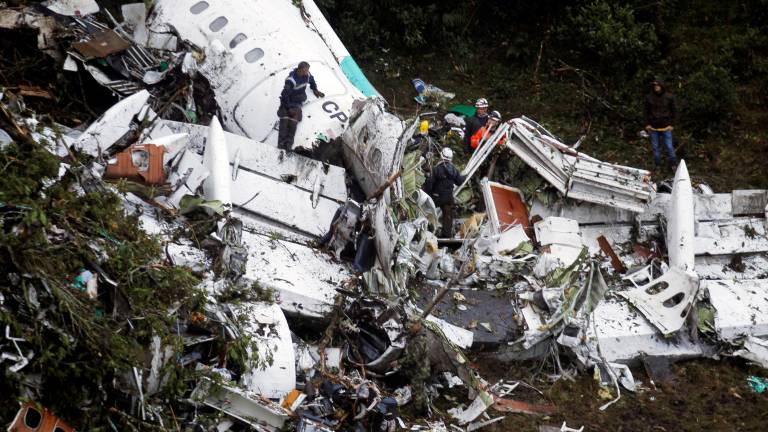 Los trabajadores del equipo de rescate buscan entre los restos del avión