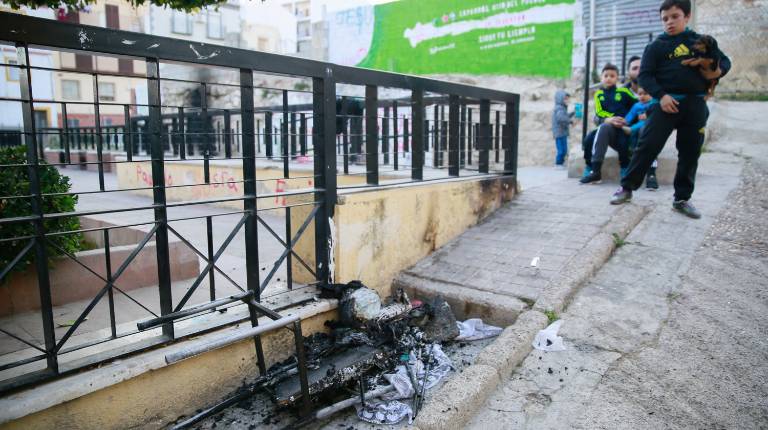 RESTOS. <i>Un hombre y tres niños observan el estado en el que quedaron varios enseres que ardieron en la vivienda situada en la Plaza de Santiago.</i>