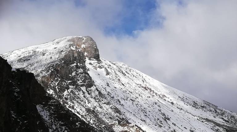 <i>La mole del pico Almadén, por su cara sur, se recorta sobre el fondo azul del cielo y sobrecoge a quien la contempla.</i>