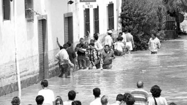 1996. <i>Vecinos rescatan a una familia, mientras otros residentes contemplan la situación.</i>