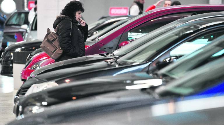 DECISIÓN CLAVE. <i>Una mujer pasea por una edición del Salón del Automóvil mientras que repasa los vehículos.</i>